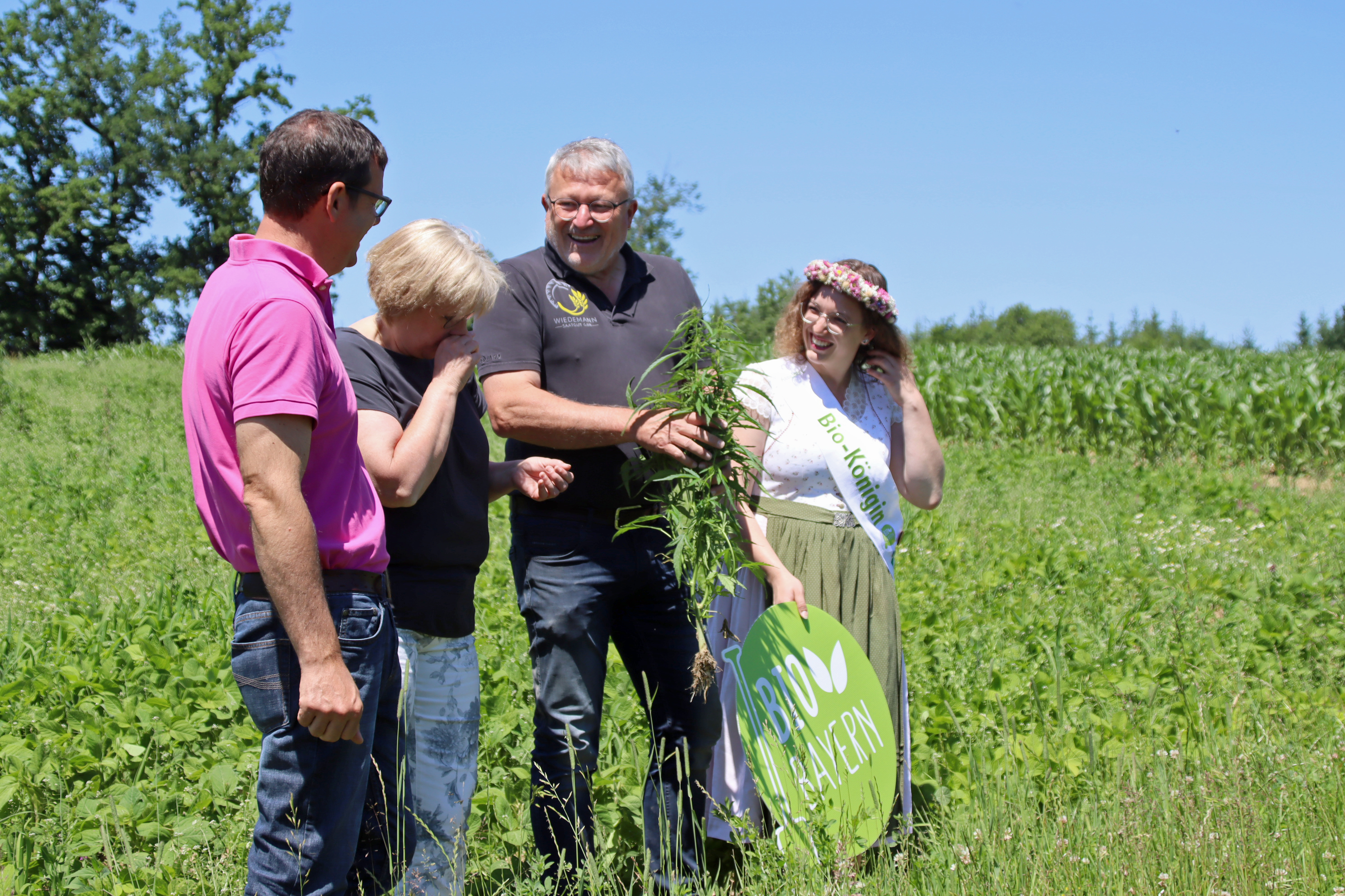 Bio-Bayern-Tour-Schwaben-2 vier Personen auf einem Feld mit einer Hanfpflanze in der Hand