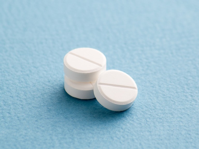 Drei Antibiotika-Tabletten auf blauem Grund