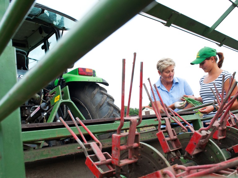 Zwei Landwirtinnen auf dem Feld neben einem Traktor