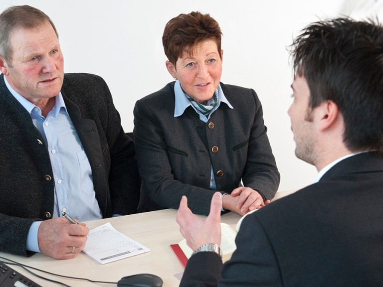 Ein älteres Ehepaar lässt sich an ihrer BBV-Geschäftsstelle von einem Fachberater beraten