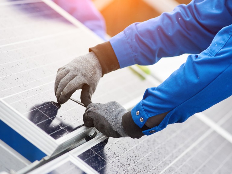 Ein Techniker installiert eine Solaranlage auf einem Dach