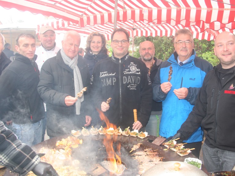 Grillmeister Martin Schulz und die Besucher des Bauernmarktes an einem Grill