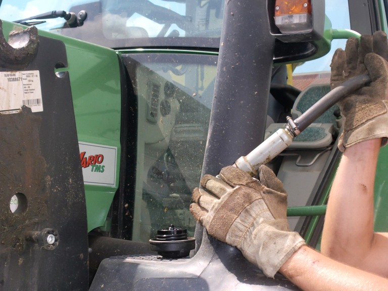 Eine Landwirtin füllt den Tank ihres Traktors
