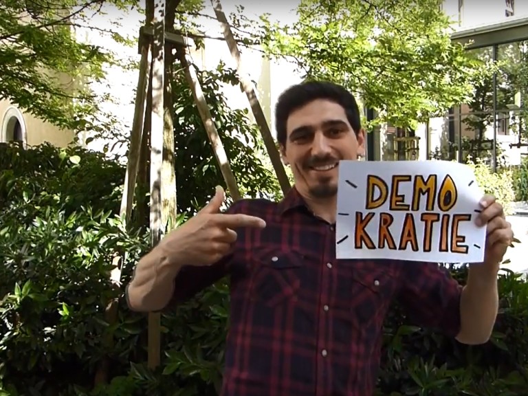 Herr Funke hält ein Demokratie Schild hoch