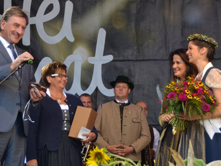 BBV-Vizepräsident Günther Felßner mit Landesbäuerin Anneliese Göller gratulieren der frisch gekrönten Biokönigin Carina I. auf der Bühne im Rahmen der Bauernmarktmeile am Odeonsplatz in München.