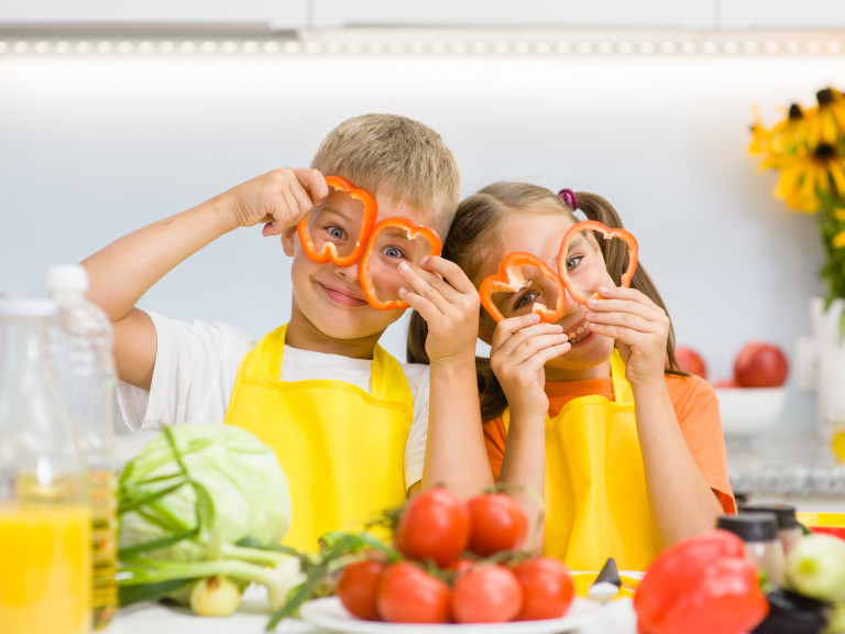 Kinder schneiden Gemüse auf