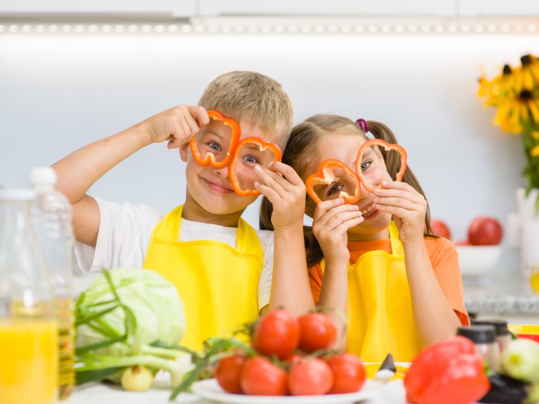 Kinder schneiden Gemüse auf