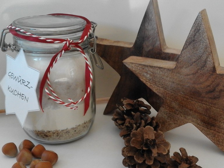 Die fertige Backmischung für Gewürzkuchen schön angerichtet in einem Glas mit weihnachltlicher Dekoration. 