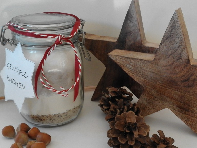 Die fertige Backmischung für Gewürzkuchen schön angerichtet in einem Glas mit weihnachltlicher Dekoration.