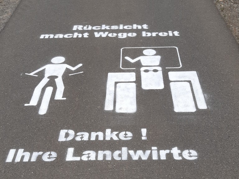 Schrift und Bild auf Feldweg