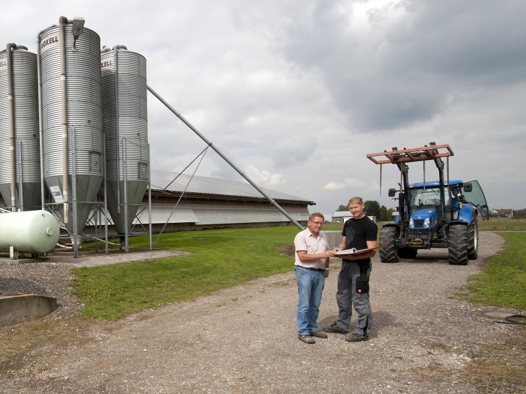 Zwei Landwirte auf einem Betrieb im Gespräch. 