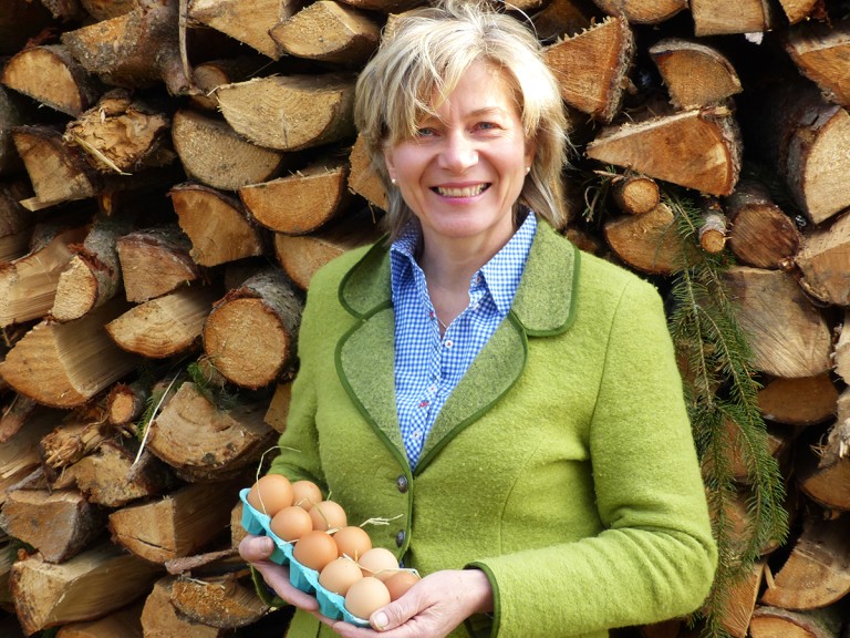 Bäuerin Rosmarie Böswirth vor Holz mit Eiern