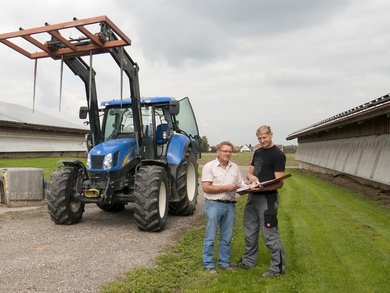 Zwei Landwirte unterhalten sich auf einem Bauernhof.