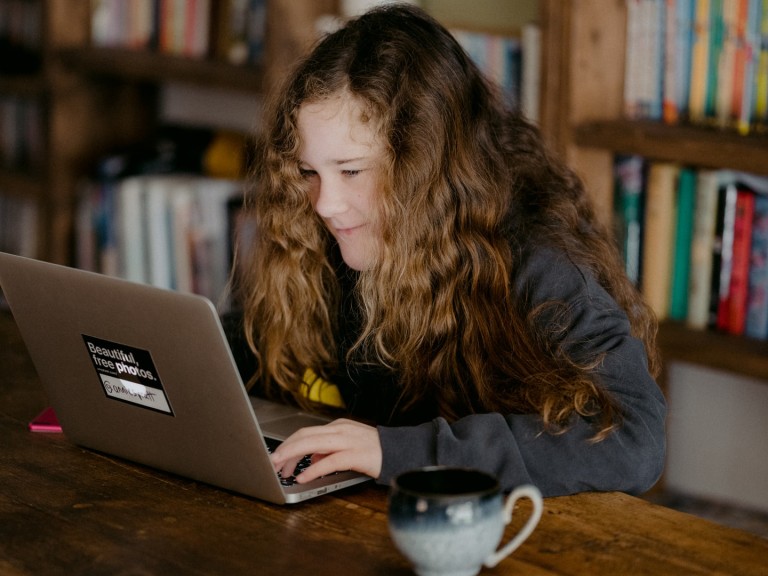 Ein junges Mädchen lernt daheim am Macbook