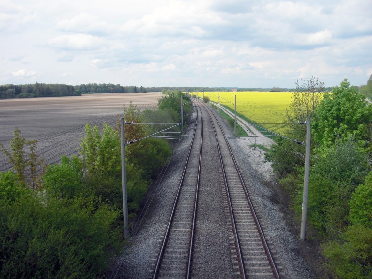 Bahngleise in ländlicher Landschaft.