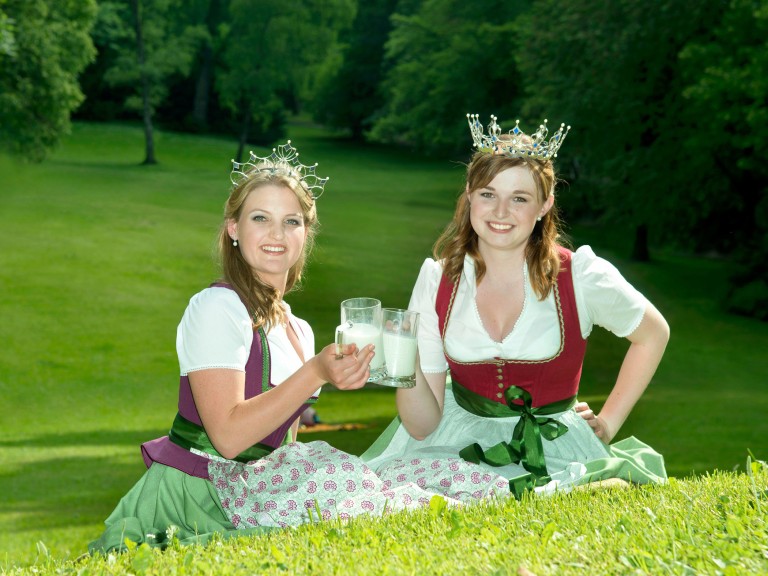 Milchprinzessin Miriam Weiß und Milchkönigin Beatrice Scheitz auf einer Wiese.
