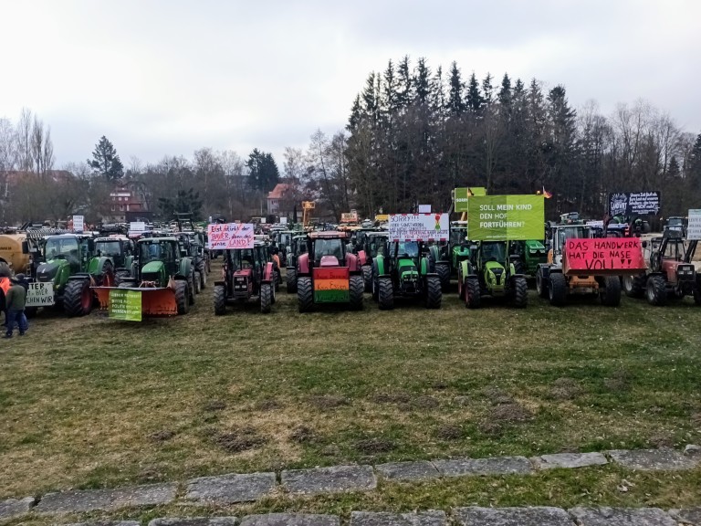 Schlepper aufgereiht mit Protesttafeln an der Frontseite