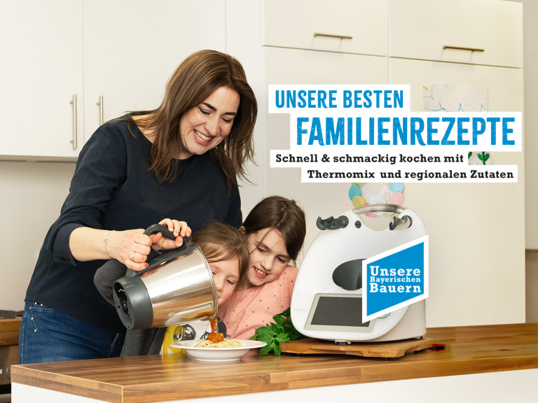 Frau mit Kinder steht am Thermomix