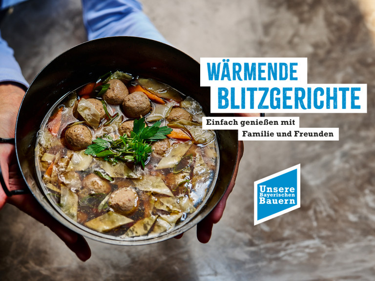 Ein Kochtopf mit Suppe, der in den Händen gehalten wird