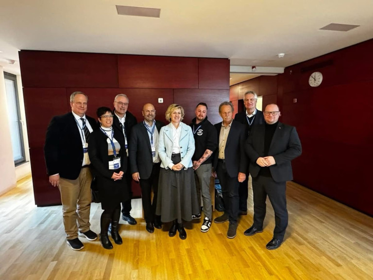 Mitarbeiter stehen vor einer roten Wand
