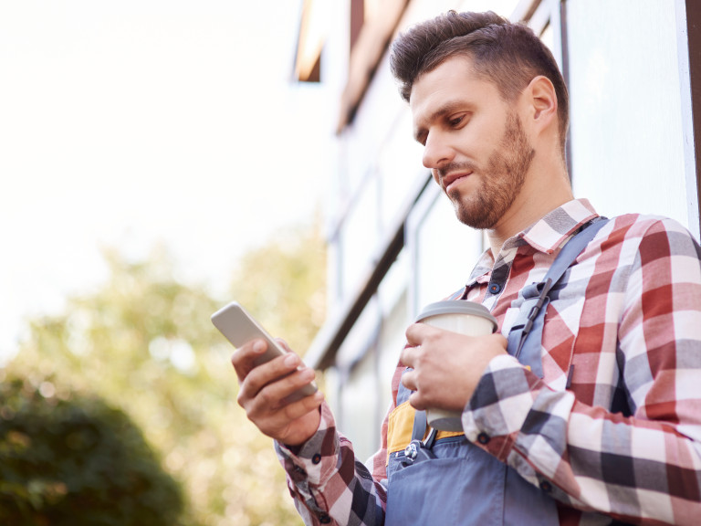 Junger Landwirt schaut in sein Handy