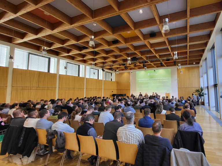 Blick durch Vortragsraum über Publikum zum Podium