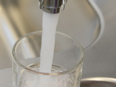 Wasser läuft in ein Glas