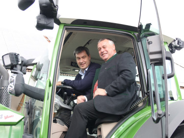 Bauernpräsident Heidl und Ministerpräsident Söder sitzen auf einem Schlepper mit RTK Signal