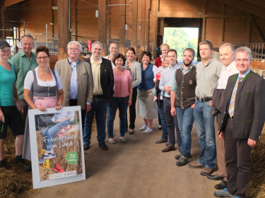 Die Landfrauen Kreisvorstandschaft mit Landtagskandidaten bei der Betriebsbesichtigung vom Betrieb Singer im Stall auf dem Futtertisch