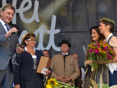 BBV-Vizepräsident Günther Felßner mit Landesbäuerin Anneliese Göller gratulieren der frisch gekrönten Biokönigin Carina I. auf der Bühne im Rahmen der Bauernmarktmeile am Odeonsplatz in München. 