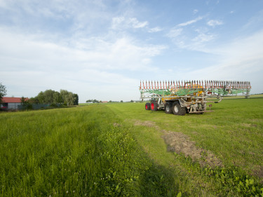 Ein Traktor mit Güllefass auf einer Wiese. 