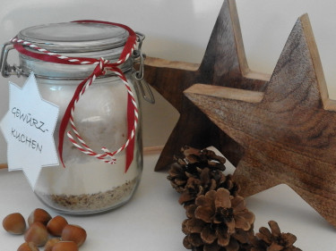 Die fertige Backmischung für Gewürzkuchen schön angerichtet in einem Glas mit weihnachltlicher Dekoration. 