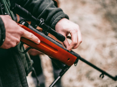 Ein Jäger hält sein Gewehr. 
