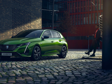Ein grüner Peugeot 308 in der City