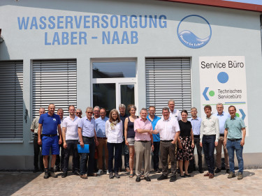 Gruppen von Menschen vor einem Bürogebäude