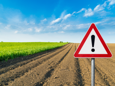Acker mit Achtung-Schild
