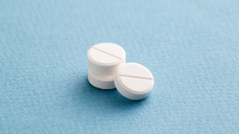 Drei Antibiotika-Tabletten auf blauem Grund