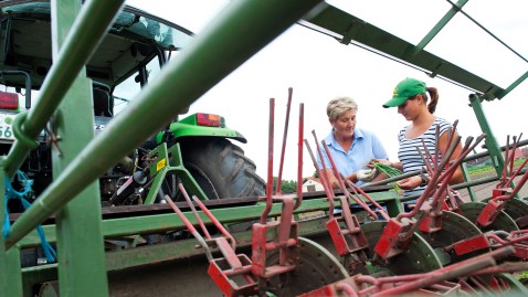 Zwei Landwirtinnen auf dem Feld neben einem Traktor
