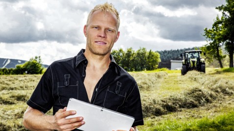 Junger Landwirt steht mit seinem Tablet-Computer auf seinem Feld