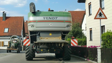 Ein großes Landfahrzeug von hinten auf einer innerörtlichen Straße