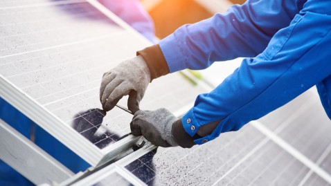 Ein Techniker installiert eine Solaranlage auf einem Dach