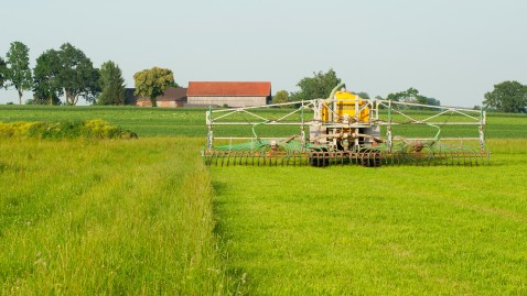 Landwirt bringt Dünger auf seinem Feld aus