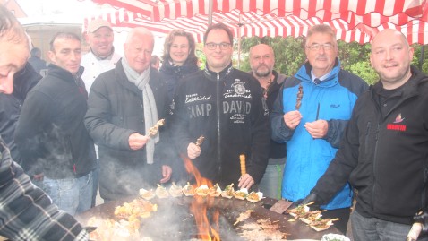 Grillmeister Martin Schulz und die Besucher des Bauernmarktes an einem Grill