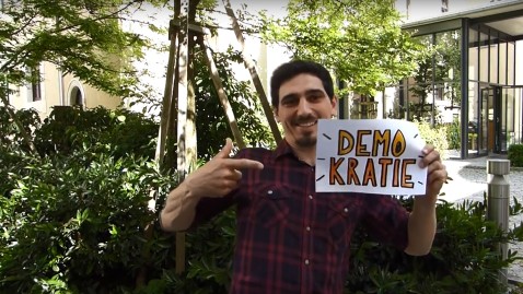 Herr Funke hält ein Demokratie Schild hoch