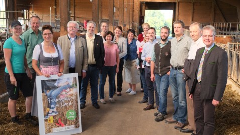 Die Landfrauen Kreisvorstandschaft mit Landtagskandidaten bei der Betriebsbesichtigung vom Betrieb Singer im Stall auf dem Futtertisch
