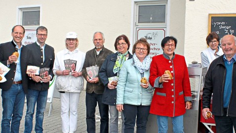 Personengruppe mit Broschüren und Grillwürstl