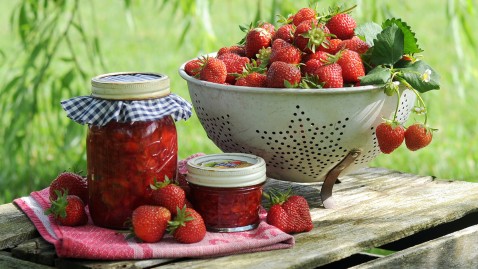 Eine Schüssel Erdbeeren steht auf einem Tisch im Garten.