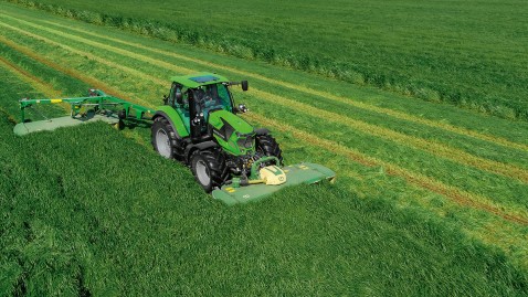 Deutz-Traktor mit Mähwerk auf grüner Wiese