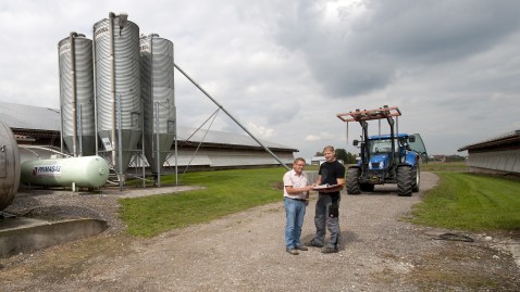 Zwei Landwirte auf einem Betrieb im Gespräch. 