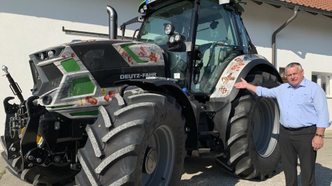 Bauernpräsident Heidl steht vor dem Traktor der #EssenAusBayern Kampagne. 